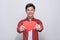 Cute handsome asian holds out a red heart made of paper for Valentine`s Day on a white background with copy space