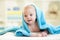 Cute happy baby boy hidden in blue towel after
