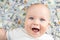 Cute happy baby boy smiling with hundred dollar bills background. Adorable kid having fun lying over american cash currency bankno