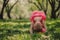 Cute happy baby girl in funny pink romper walking outdoor in spring garden