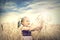 Cute happy baby playing on wheat field