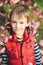 Cute happy boy child outdoors. Spring day. Little boy face. Spring pink sakura blossom. Kids fashion and trendy clothes