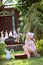 Cute happy child girl playing toy wash in summer sunny garden