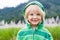 Cute, happy child in hoodie in front of a field