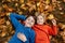 Cute happy children, siblings, boys, playing with knitted toys in the park, autumntime