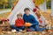 Cute happy children, siblings, boys, playing with knitted toys in the park, autumntime