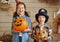 Cute happy children sister and brother holding Jack-o-lanterns orange pumpkins with funny faces