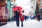 Cute happy family walking along snowy city street, winter holidays