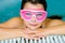 Cute happy girl in pink goggles mask in the swimming pool