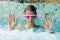 Cute happy girl in pink goggles mask in the swimming pool