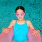 Cute happy girl in pink goggles mask in the swimming pool