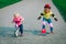 Cute happy girls on bike and skateboard ride, kids sport