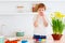 Cute happy kid painting easter eggs at the kitchen desk