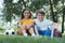 cute happy kids with soccer and rugby balls sitting on grass and smiling