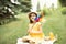 Cute happy little girl in a hat having fun in park meadow. Child sitting on a blanket holding pinwheel and look at camera. Picnic