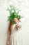 Cute happy little girl Laughing in Christmas atmosphere with gift boxes and magic lights holding spruce branch