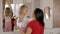 Cute happy little girl is standing near mirror with cheerful young mother.