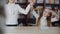 Cute happy playful schoolgirls dancing at desk in library