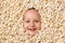 Cute happy pretty little girl face in popcorn. Top view of the child