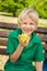 Cute happy school child eating homemade muffin outdoors