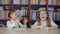 Cute happy schoolgirls sitting at desk and laughing in classroom