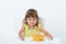 Cute happy smiling emotional and positive girl 3 year old in yellow t-shirt eating cereal flakes at the table isolated on white