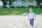 Cute happy smiling little Asian  toddler boy standing barefoot on sandy tropical beach in summer vacation in front of Beachfront R