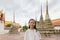 Cute happy smiling tourist girl at Wat Phra Chetuphon or Wat Pho is a Buddhist temple in the city of Bangkok,Thailand, summer vac
