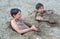 Cute happy teenage boys playing in the sand