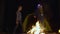 Cute happy teenagers dancing near campfire at night time