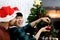 Cute happy young LGBT couple holding ball ornament to decorate Christmas tree, gay male lover sharing sweet special moment on