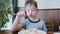 Cute healthy preschool kid boy eats fish and pasta noodles sitting in nursery cafe. Happy child eating healthy organic