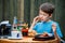 Cute healthy teenager boy eats hamburger and potato