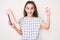 Cute hispanic child girl holding book and pencil screaming proud, celebrating victory and success very excited with raised arms