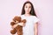 Cute hispanic child girl holding teddy bear thinking attitude and sober expression looking self confident