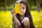 Cute hispanic girl hiding over yellow leaf