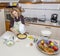 Cute housewife prepares a cake in a messy kitchen