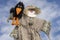 Cute humanoid scarecrow together with a crow on a background of blue sky, Ukraine. Close up