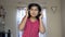 Cute Indian asian caucasian girl enjoying listening music on mobile with headphone nodding and dancing portrait front view.