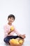 Cute indian/Asian little boy holding Mango basket in hand and giving multiple expressions. isolated over white background