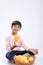 Cute indian/Asian little boy holding Mango basket in hand and giving multiple expressions. isolated over white background