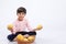 Cute indian/Asian little boy holding Mango basket in hand and giving multiple expressions. isolated over white background