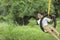 Cute indian child playing with swing made by tyre and rope on tree at green field