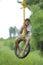 Cute indian child playing on swing made by tyre and rope on tree at green field