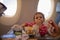 Cute infant airplane passenger eats special baby onboard meal diring flight