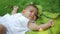 Cute infant baby sneezes two time loudly in slow motion, close-up view. Dreamy newborn baby infant lying on a grass