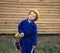 Cute inquisitive boy in a blue overalls uniform and a construction helmet with tools in his hands