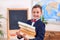 Cute inquisitive little schoolboy wears school textbooks. Back to school