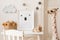 Cute interior of kid room with baby accessories, toys and poster frame.