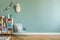 Cute interior of kid room with mint armchair, baby accessories and toys.